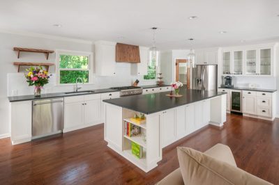 Kitchen styled with wood flooring, white cabinets, and gray countertops.