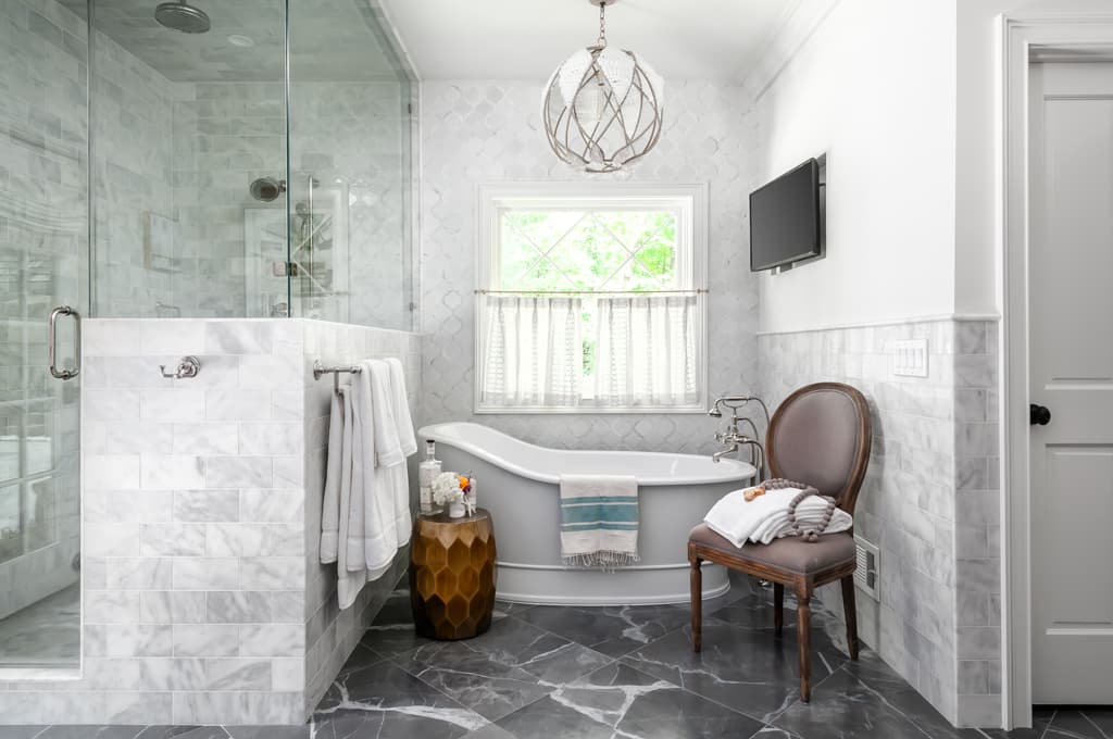 Elegant marble bathroom with freestanding shower next to freestanding tub
