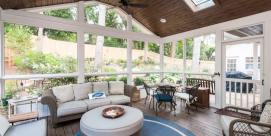 Screened in porch with furniture and a ceiling fan