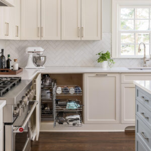A remodeled kitchen with white cabinets and a gas range