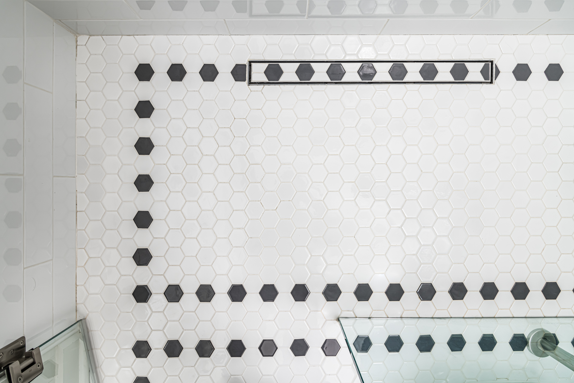 curbless shower linear drain, hexagonal tile, black and white