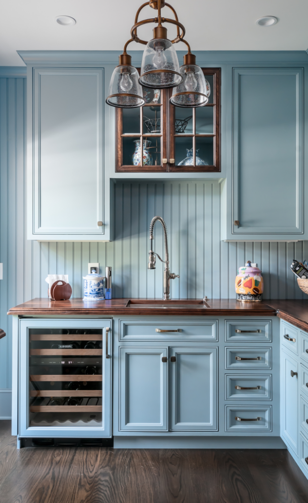 An eggshell blue kitchen with dark wooden accents and floors.
