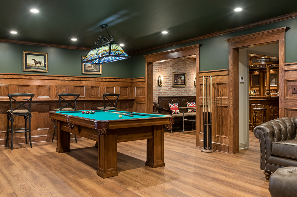 a pool table and chairs in a newly remodeled british pub inspired basement bar 10 Design Trends For 2024 Innovative Design Build renovation Atlanta