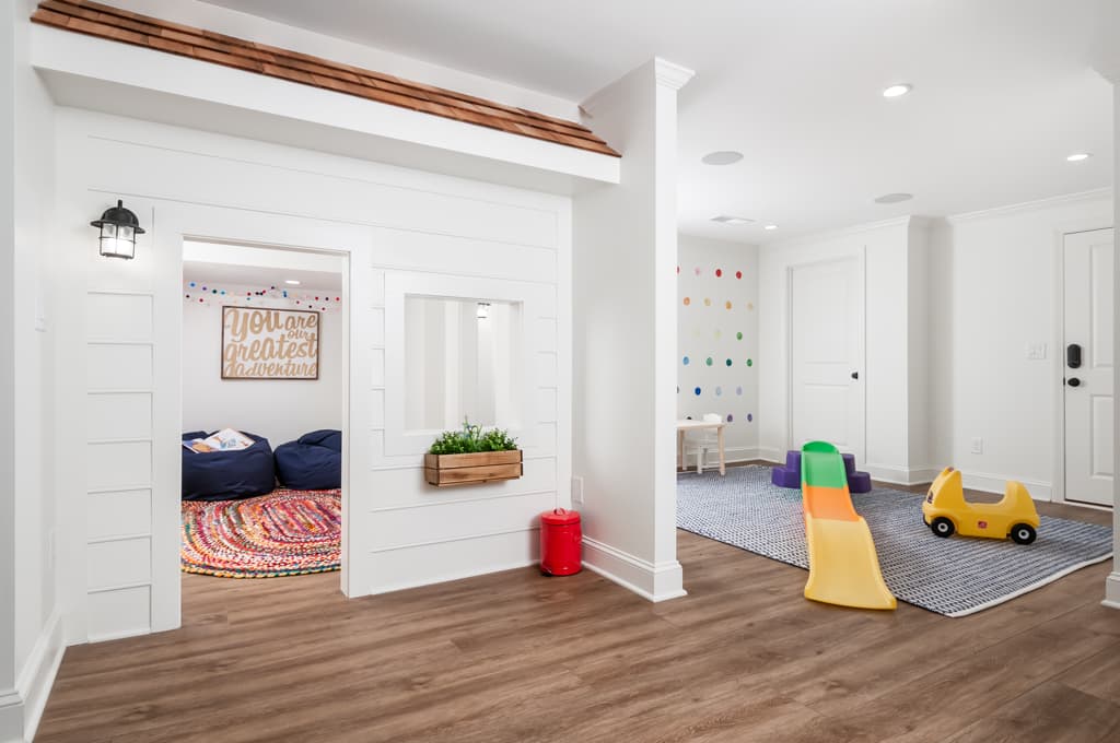 Finished basement playroom with hardwood floors and kid's toys