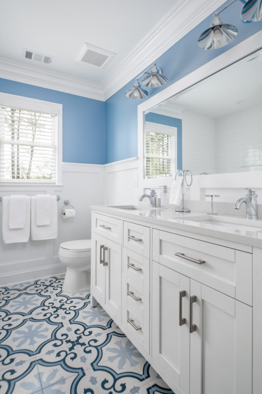 newly remodeled beach guest bath with blue walls and white vanity