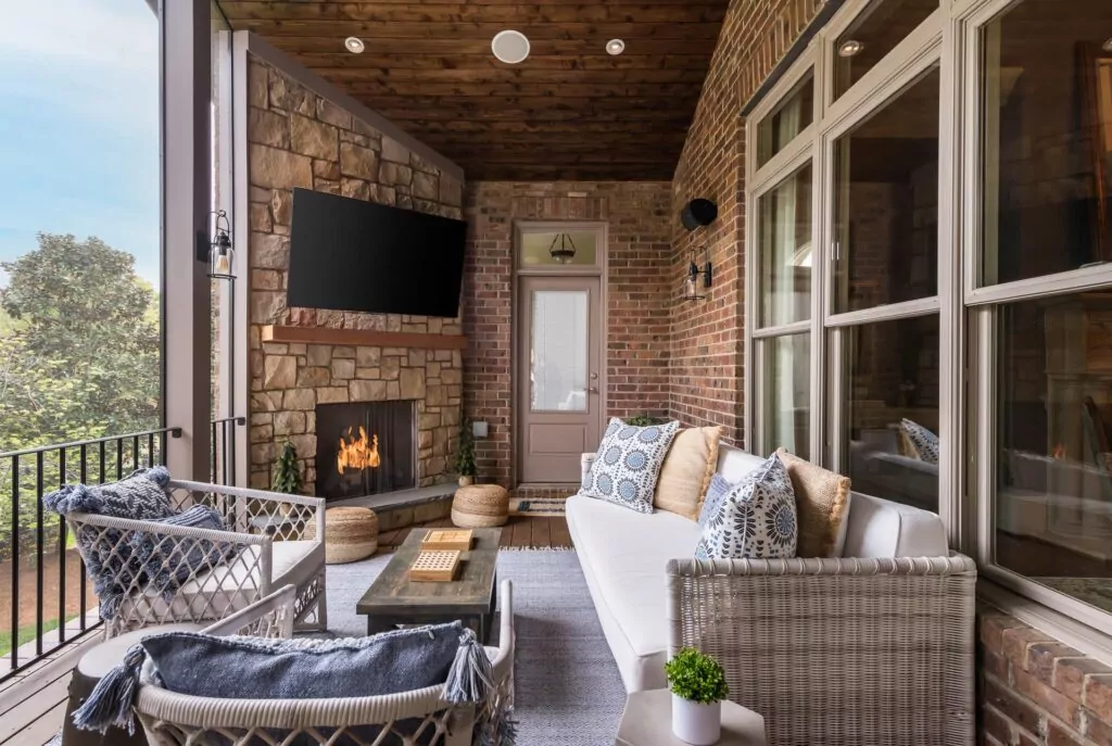 screened in outdoor porch with television and fireplace