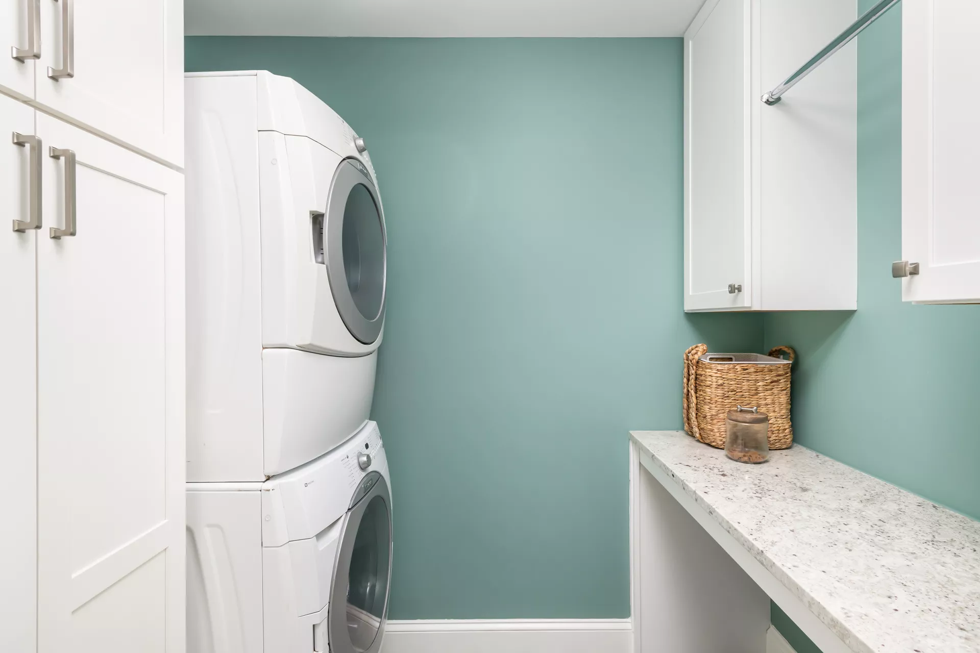 Renovated laundry room with marble counter and linen cabinets