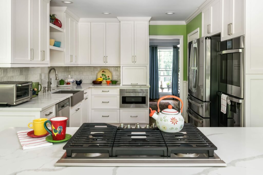 gas range with teapot and white cabinets
