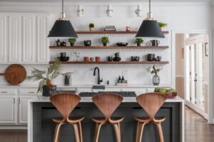 Modern kitchen design showcasing wooden stools, black & white island, and stunning floating hanging shelves.