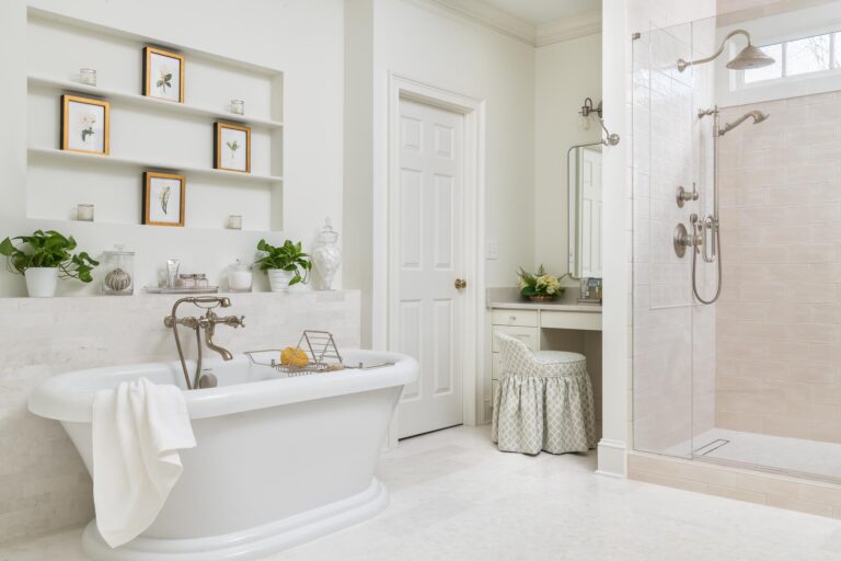 An all-white bathroom with a makeup vanity, a bathtub and a shower with silver fixtures.