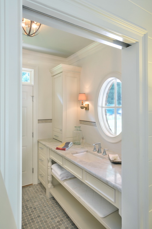 a bathroom with double sinks and a round window