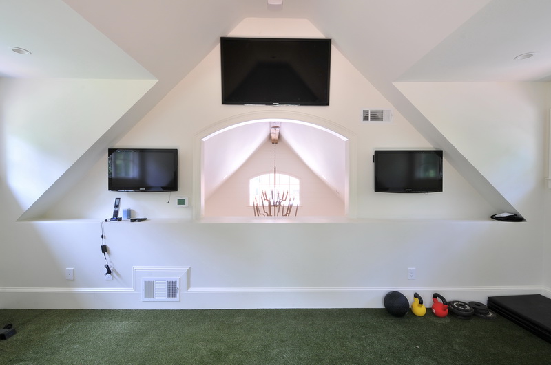 a room with three televisions mounted on the wall
