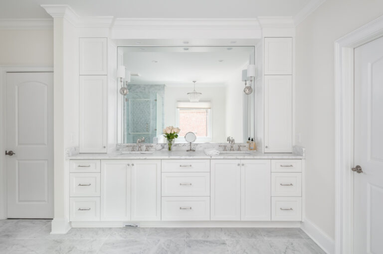 a bright white bathroom with two sinks and a large mirror