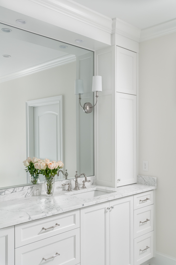 a white bathroom with marble counter tops