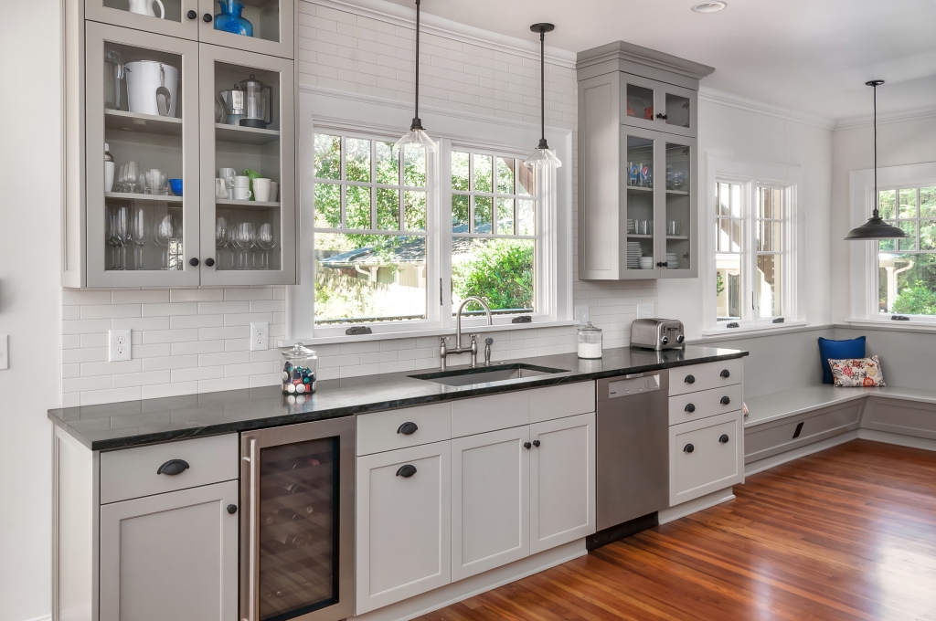 Newly renovated kitchen with white and gray cabinets and window above sink