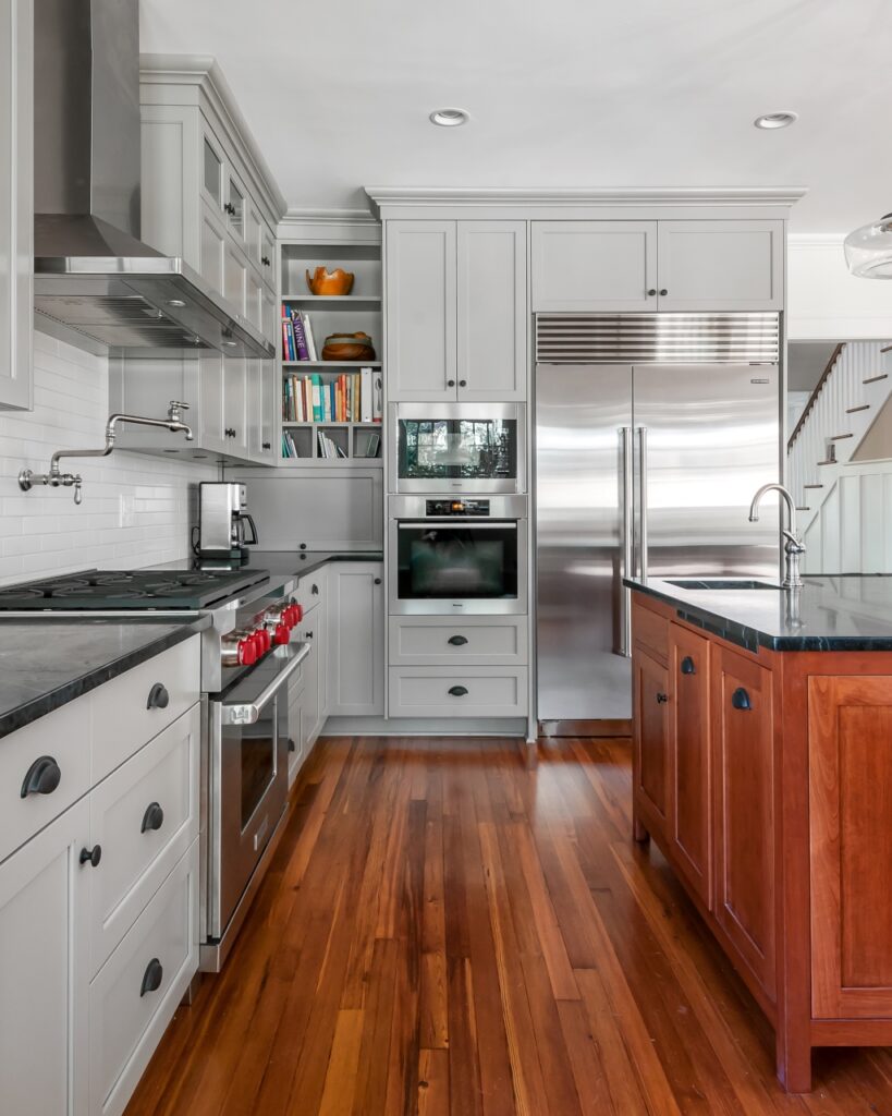 New kitchen remodel with wooden floors, white cabinets, and stainless steel appliances