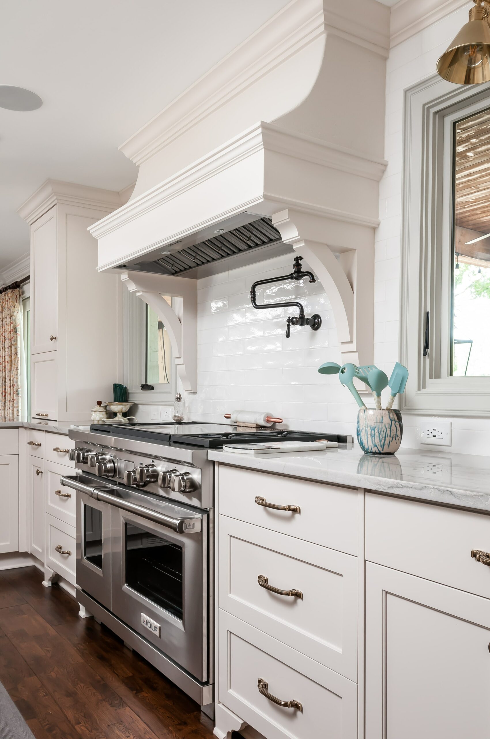 White kitchen renovation with stainless steel gas range stove