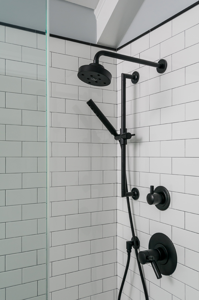 luxurious black shower head and white tile shower