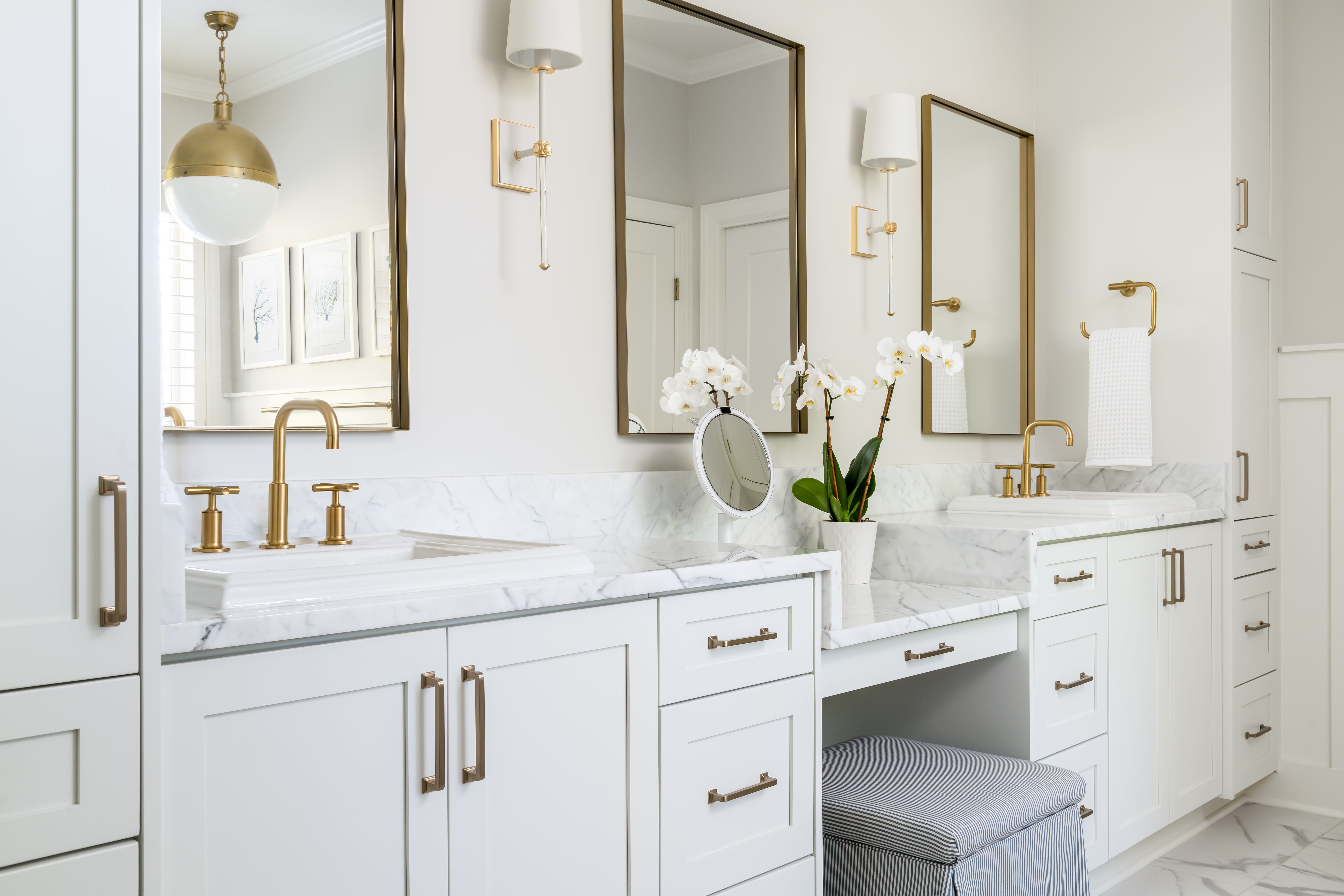 a newly remodeled white bathroom with two sinks and mirrors