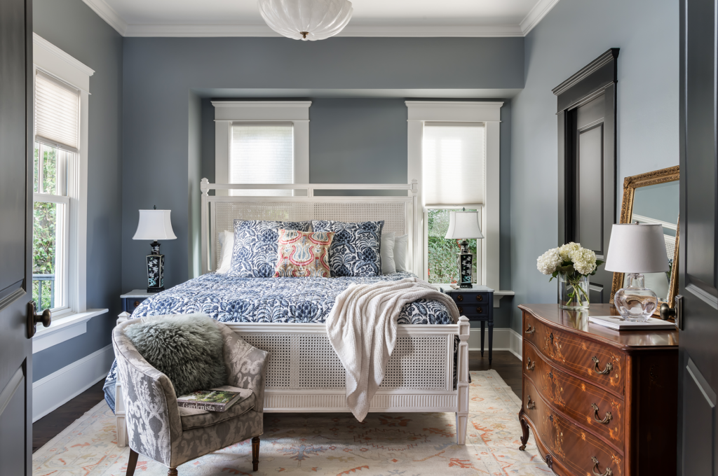 A newly remodeled master bedroom with tall windows and bright decor