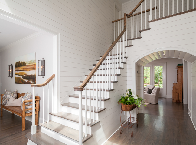a staircase in a house with white walls and wood floors