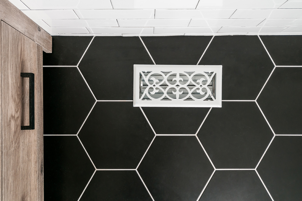 a black and white bathroom with hexagonal tiles