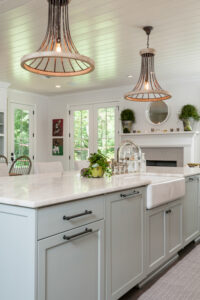 a large white kitchen with unique light fixtures and a center island