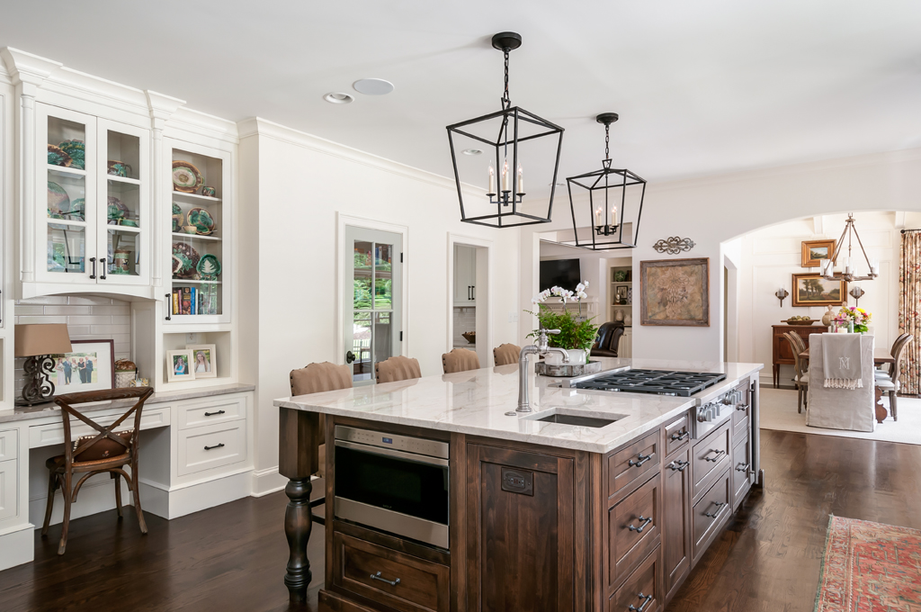 a large kitchen with a wood and marble center island in the middle