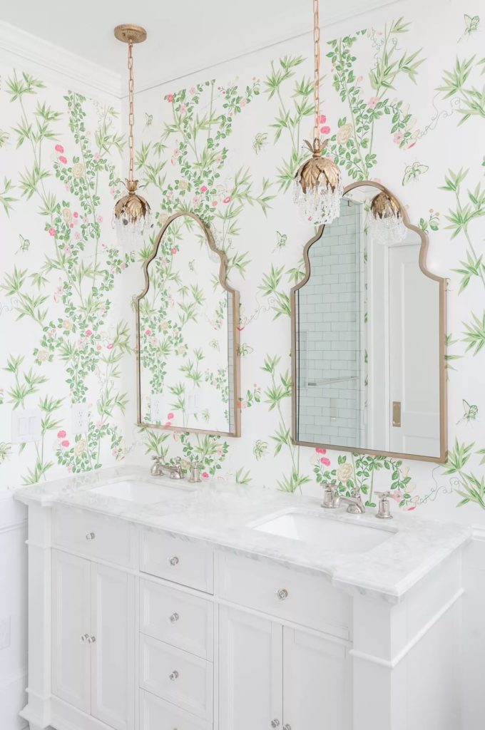 Vintage charm bathroom design with floral wallpaper, white vanity, and gold accents