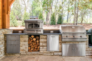an outdoor kitchen with stainless steel appliances and wood logs