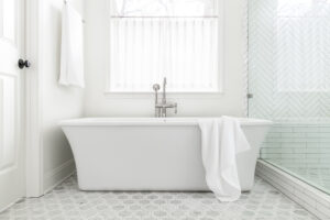 a white freestanding bath tub under a window
