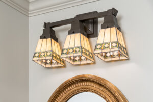 a bathroom light fixture with three lamps on it