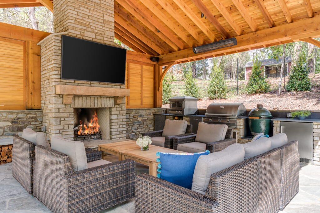 outdoor covered patio with couches, fireplace & TV