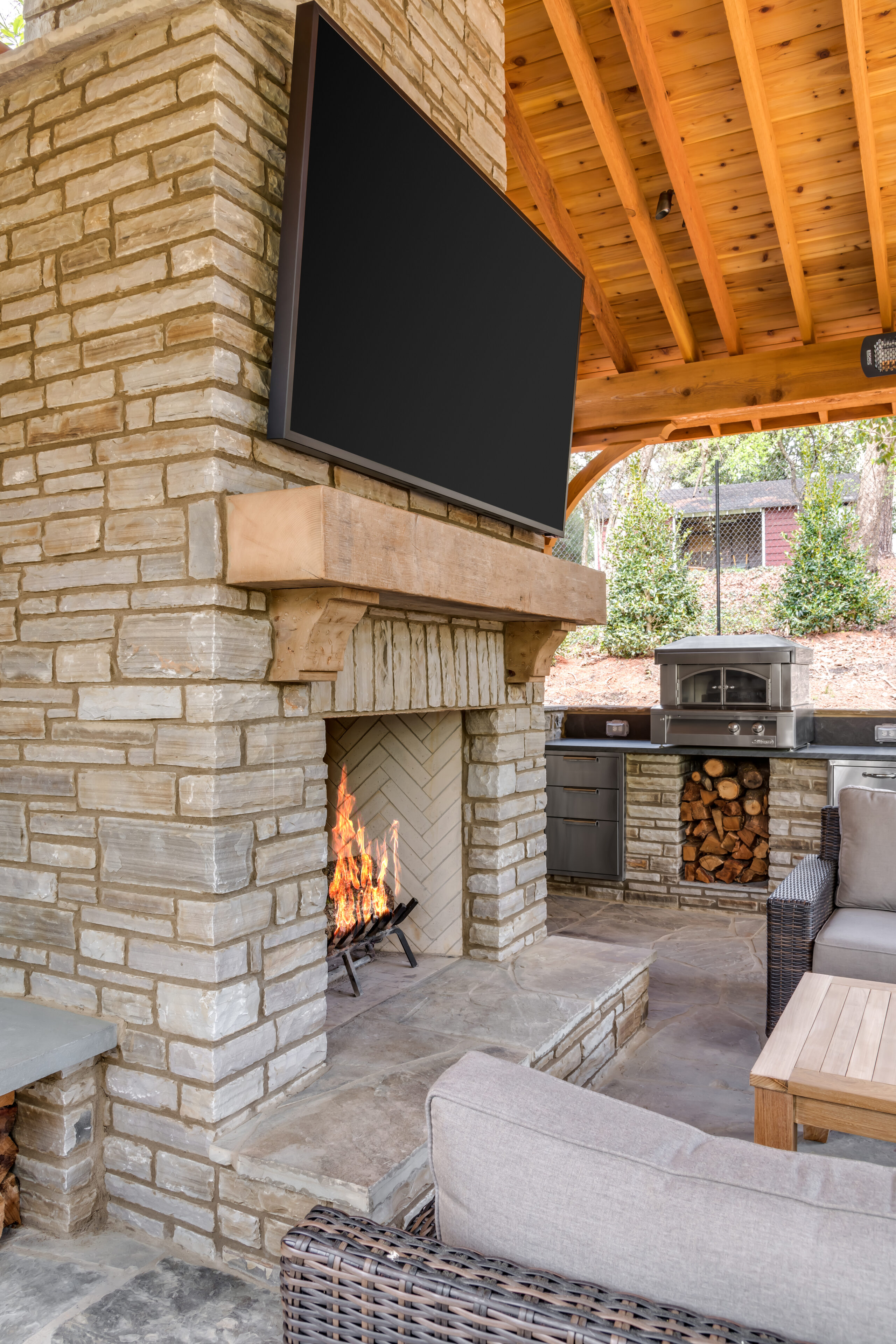 outdoor fireplace and tv in living area under cover