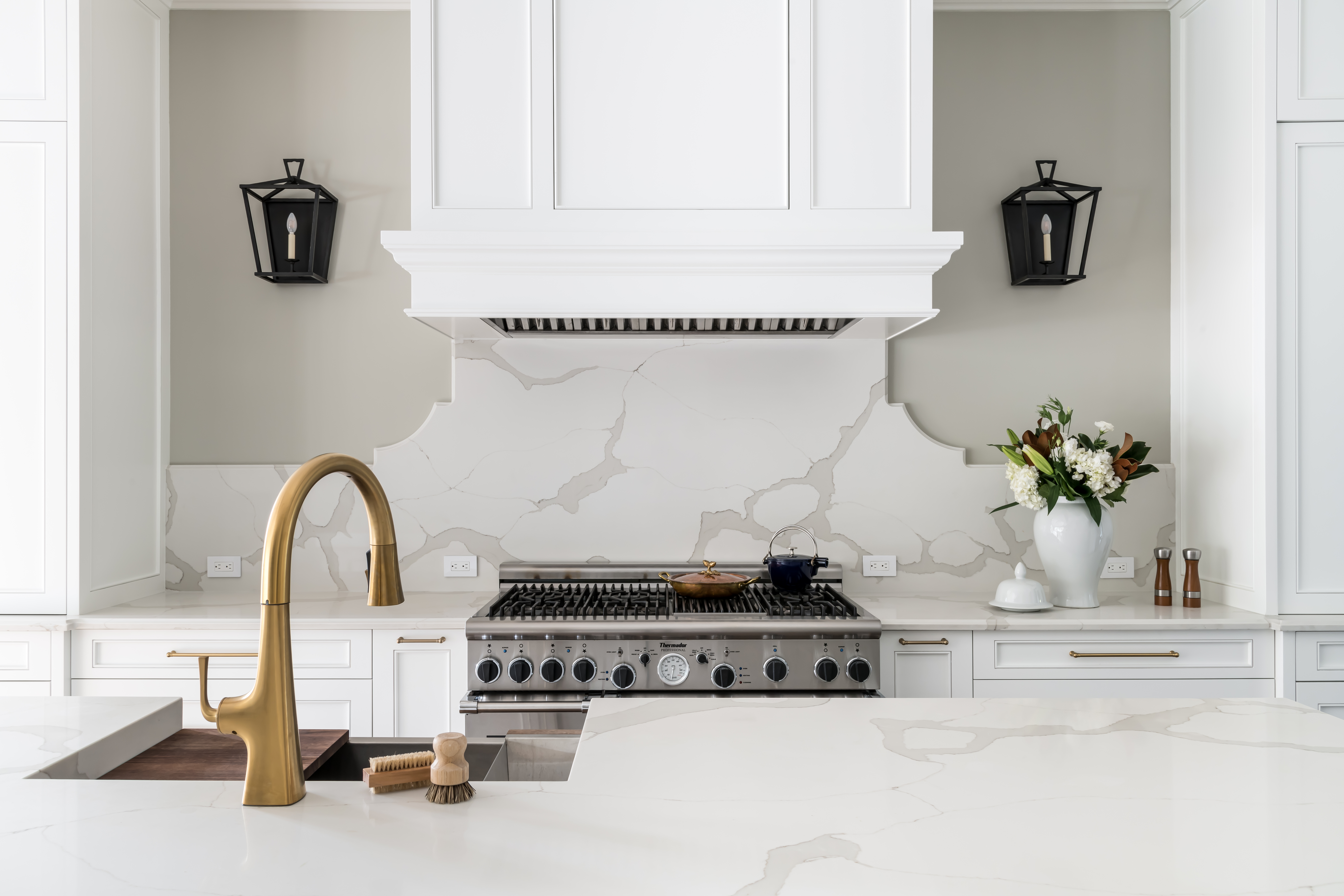 kitchen with brass fixtures and a white stove hood
