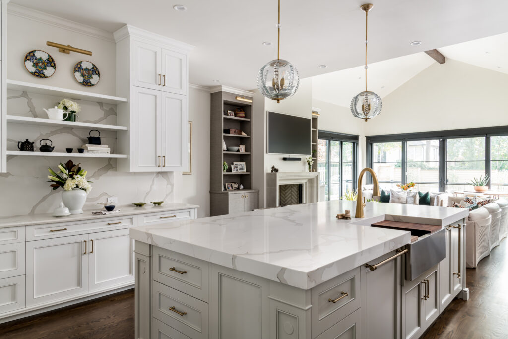 remodeled kitchen with large island, grey cabinets, built in shelves, and overhead lighting