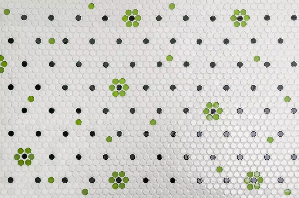 a white wall with green and black dots on it