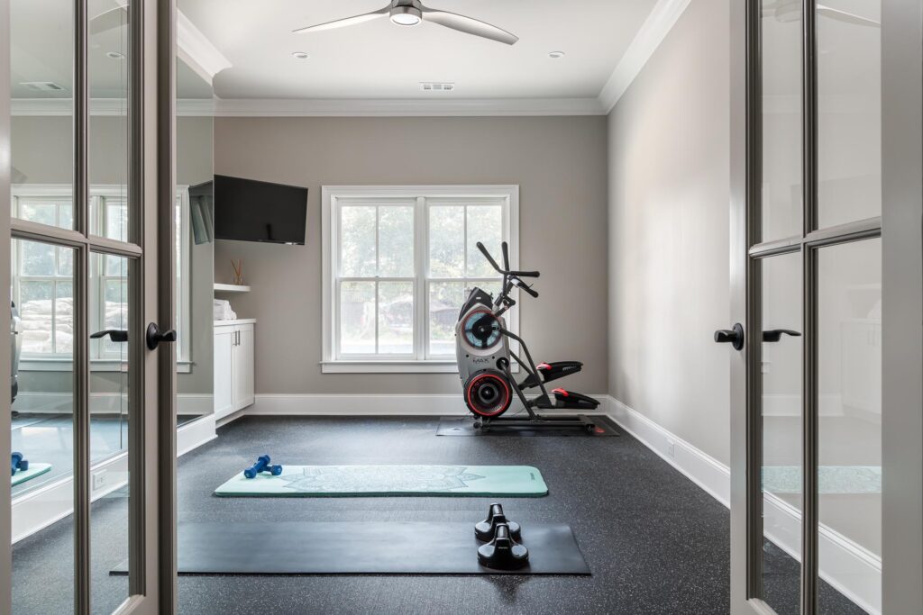 a home gym with a large window, exercise mats, and equipment