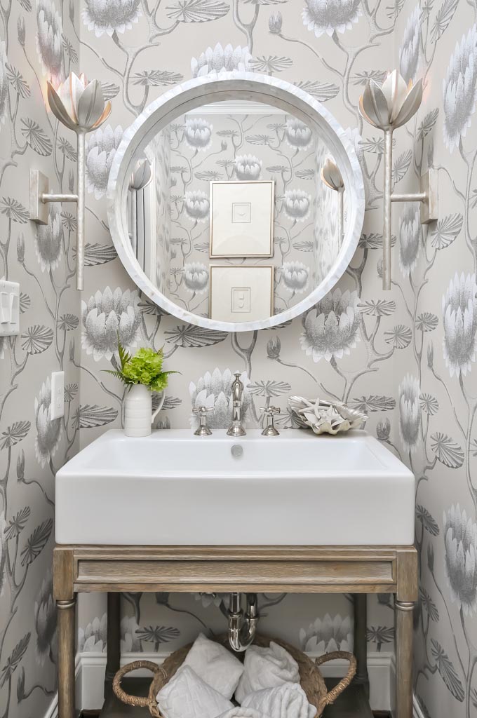 a newly remodeled, wallpapered bathroom with flower light features