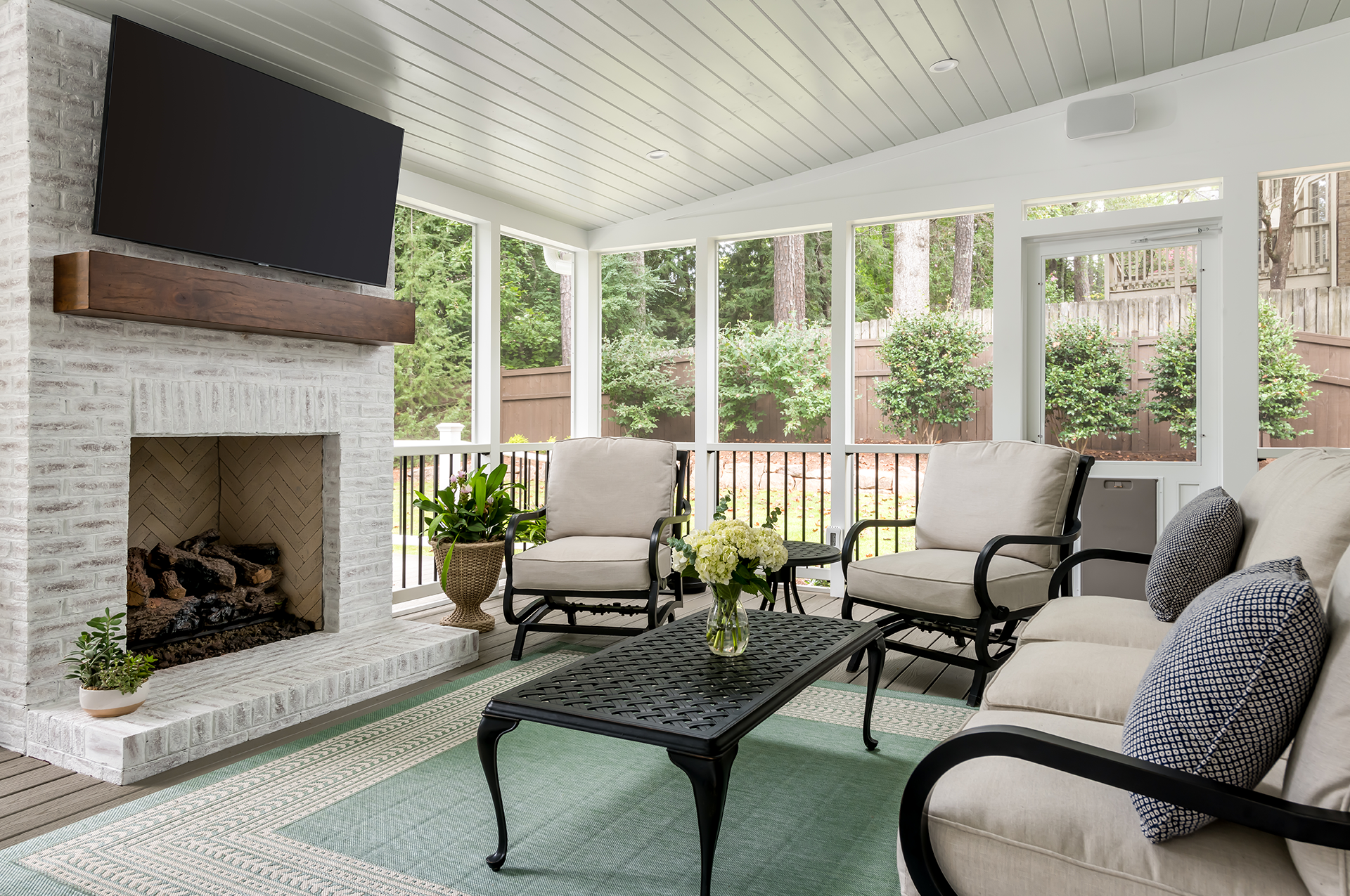 A newly remodeled screened porch with TV and seating