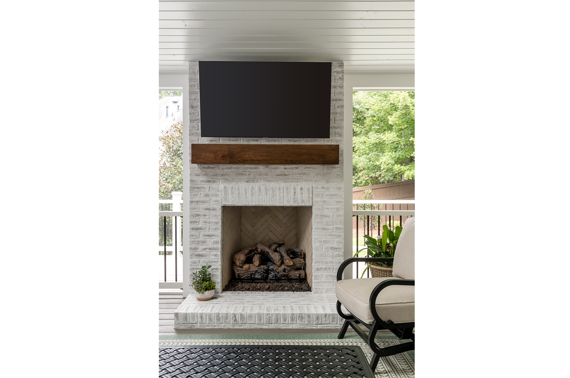 A newly remodeled screen porch with TV and fireplace