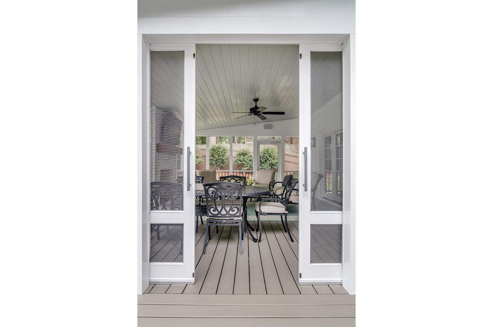 A newly remodeled covered porch with white screen doors