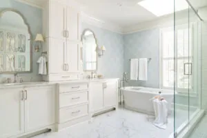 primary suite with baby blue wallpaper, freestanding tub, and glass surround shower
