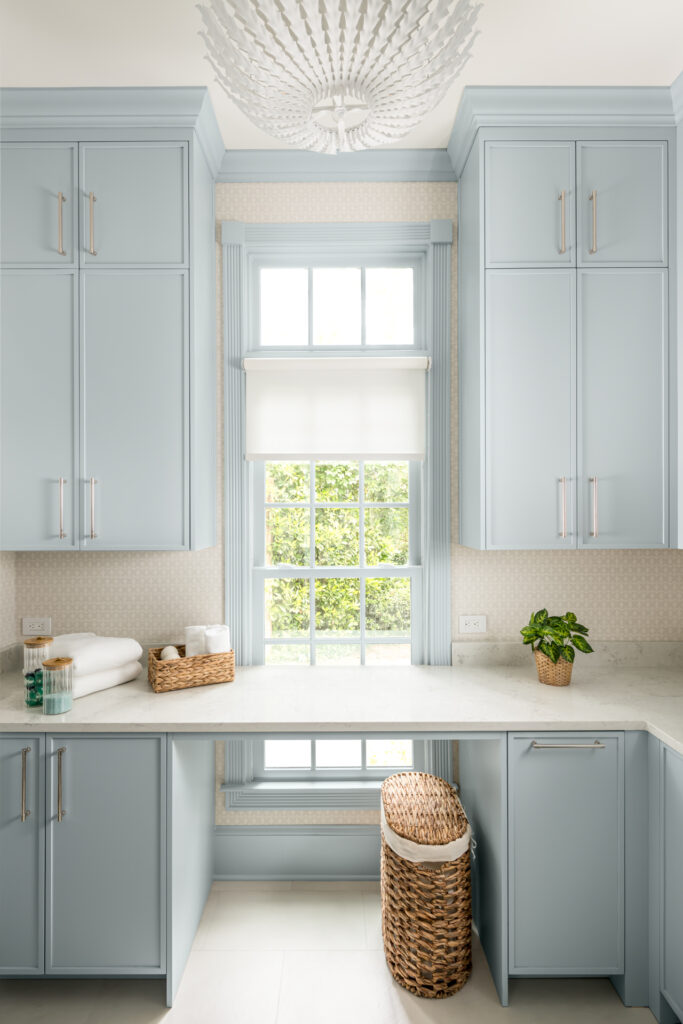a kitchen with blue cabinets and a chandelier