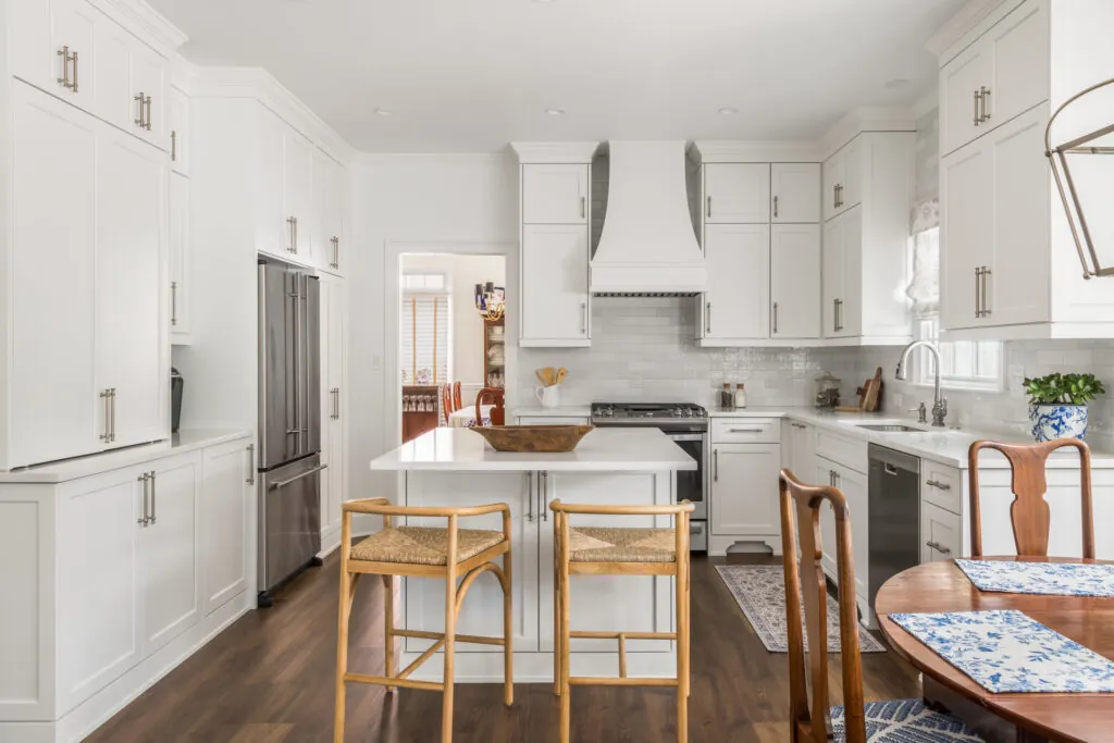 a kitchen with white cabinets and wooden floors
