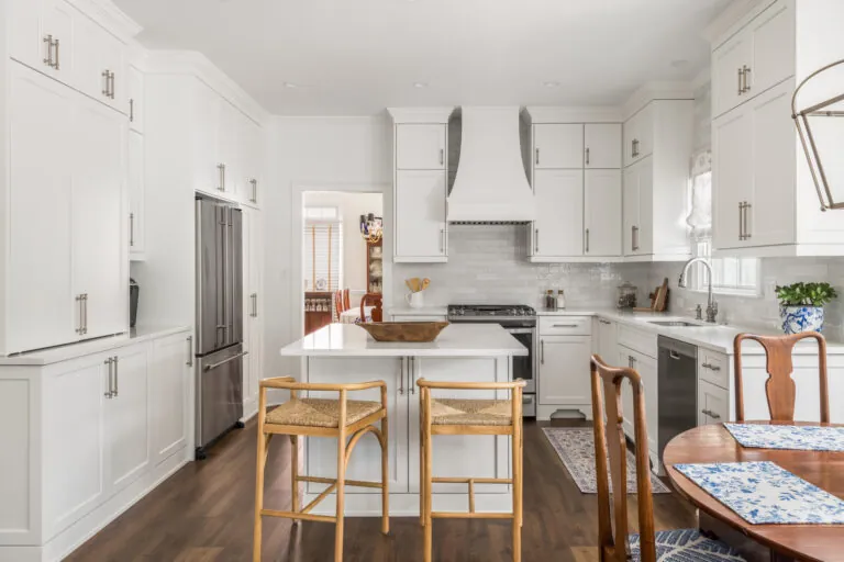 a kitchen with white cabinets and wooden floors
