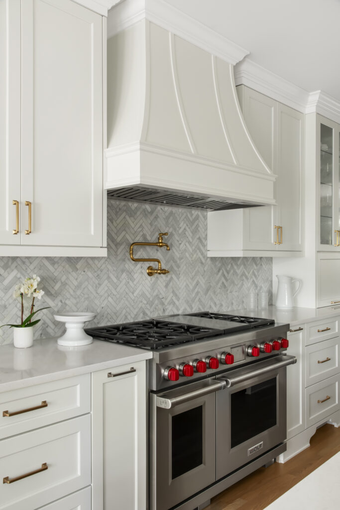 a kitchen with white cabinets and a stainless steel stove