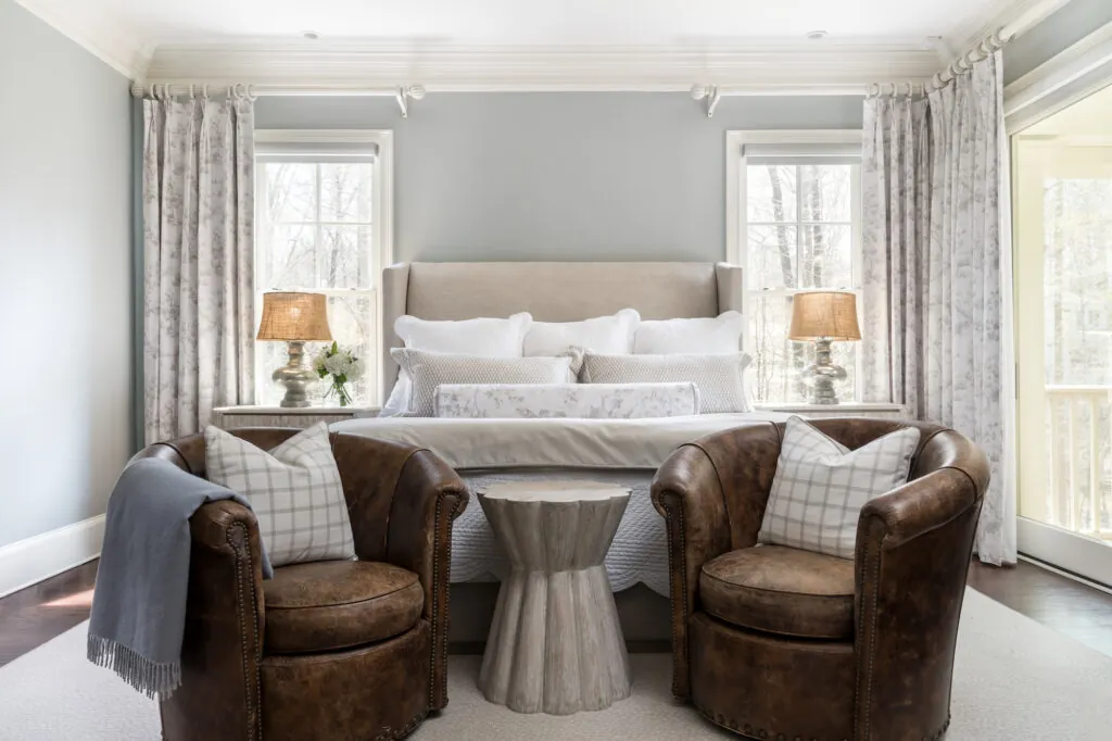 a bedroom with two chairs and a bed