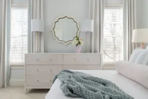 a bedroom with a bed, dresser and mirror