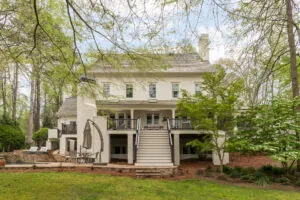a large white house in the middle of a wooded area